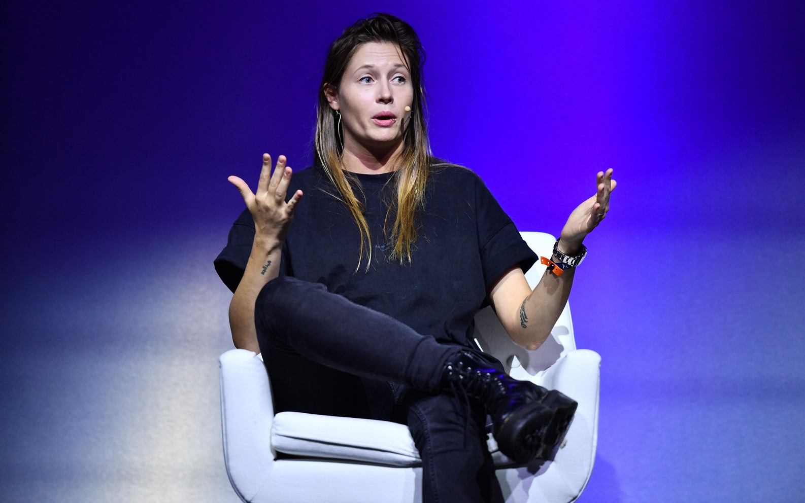Charlotte de Witte speaking on stage at Web Summit 2021 in Lisbon, gesturing with both hands against a violet-lit background.