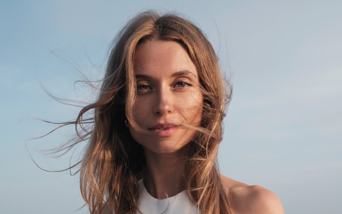 Kate Zubok wearing a white top, photographed outdoors beside the sea.